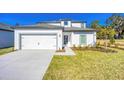 Well-manicured lawn complements this two-story home with attached garage and an inviting walkway to the front door at 13490 Leaping Water Way, Astatula, FL 34705