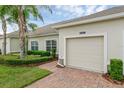 A well kept townhome showcasing a one car garage, walkway and manicured shrubs at 3825 Quaint Ln # C, Clermont, FL 34711