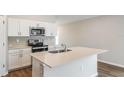 Modern kitchen with white cabinets, stainless steel appliances, and center island sink at 9565 Sw 62Nd Ct, Ocala, FL 34476