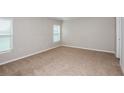 Spacious bedroom featuring neutral carpet, two large windows, and bright neutral paint at 9569 Sw 62Nd Ct, Ocala, FL 34476