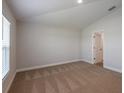 Empty bedroom with neutral carpet, natural light, and en-suite bathroom access at 6074 Sw 97Th St, Ocala, FL 34476