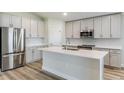 Modern kitchen features stainless steel appliances, center island, and gray cabinets at 6074 Sw 97Th St, Ocala, FL 34476