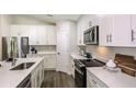 Modern kitchen with white cabinets, stainless steel appliances, and quartz countertops at 6243 Sw 97Th St, Ocala, FL 34476