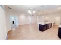 Bright open-concept living space with hardwood floors, neutral walls, and a modern kitchen island at 6855 Mossy Oak Ln, Lakeland, FL 33810