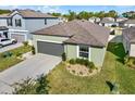 Aerial view of a well-maintained property with landscaped lawn, a grey roof and neutral stucco exterior at 4310 Trotters Way, Lakeland, FL 33801