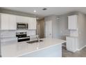 Modern kitchen with white cabinets, stainless steel appliances, quartz countertops, and an island sink at 5429 Sw 85Th Avenue Rd, Ocala, FL 34481