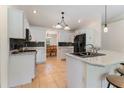 Bright kitchen featuring white cabinetry, stainless appliances and granite counters at 4995 County Road 121D, Wildwood, FL 34785