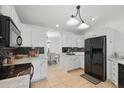 Well-lit kitchen with modern appliances, white cabinetry, and stylish backsplash at 4995 County Road 121D, Wildwood, FL 34785