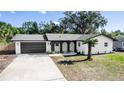 Newly renovated home with stylish gray garage and palm tree landscaping at 1309 Buccaneer Ave, Deltona, FL 32725