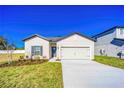 Inviting single-story home with a two-car garage, enhanced by a lush green lawn at 13454 Leaping Water Way, Astatula, FL 34705