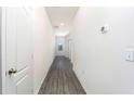 White hallway with grey wood-look floors and doors at 13454 Leaping Water Way, Astatula, FL 34705