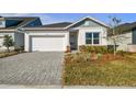 One-story home with white garage door and gray pavers driveway at 5938 Bristle Oak St, Mount Dora, FL 32757