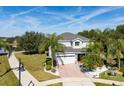 Two-story house with gray exterior, landscaping, and a pond nearby at 13438 Davenham Pt, Orlando, FL 32832