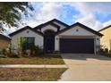 A single-story home with a manicured front lawn and an attached two-car garage at 1051 Woodlark Dr, Haines City, FL 33844