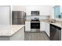Beautiful kitchen with stainless steel appliances, granite countertops, and white cabinetry at 13469 Leaping Water Way, Astatula, FL 34705