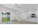Spacious living area with a sliding glass door leading to the fenced backyard and a view of the open kitchen at 13446 Leaping Water Way, Astatula, FL 34705
