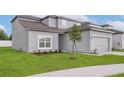 Charming home with a well manicured lawn, fresh landscaping, and neutral gray exterior paint at 13462 Leaping Water Way, Astatula, FL 34705