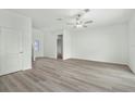 Bright living room with modern ceiling fan, light gray vinyl flooring, and white walls at 13462 Leaping Water Way, Astatula, FL 34705