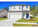 Charming two-story home with a well-manicured lawn, two-car garage, and inviting blue front door at 13465 Leaping Water Way, Astatula, FL 34705