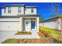 Inviting entrance to this charming home showcasing a bright blue door and modern landscaping at 13465 Leaping Water Way, Astatula, FL 34705