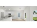 Open kitchen with granite countertops, white cabinets, and stainless microwave at 13466 Leaping Water Way, Astatula, FL 34705