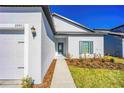 Close up on home entrance with front door and landscaped front yard at 13473 Leaping Water Way, Astatula, FL 34705