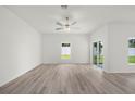 Bright living room featuring hardwood floors, ceiling fan, and natural light at 13477 Leaping Water Way, Astatula, FL 34705