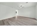 Spacious living room with wood-look flooring, neutral paint, and ceiling fan at 13485 Leaping Water Way, Astatula, FL 34705