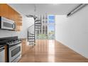 Open floorplan featuring spiral staircase, hardwood floors, and ample natural light from large windows at 150 E Robinson St # 221, Orlando, FL 32801