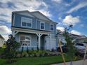 The exterior elevation of this two-story house with blue siding shows the front yard and attached garage at 13467 Panama Beach Ct, Orlando, FL 32827