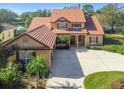 Two-story house with three car garage and terracotta tile roof at 2024 Capri Ln, Mount Dora, FL 32757