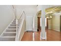 Bright foyer with a staircase and a front door leading to a large living area with hardwood floors and high ceilings at 2024 Capri Ln, Mount Dora, FL 32757