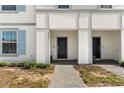 Front entry of townhouses featuring a walkway and black doors at 7614 Oak Spring Ln, Davenport, FL 33837