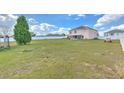 Expansive fenced backyard with lush lawn and mature tree, perfect for outdoor activities and relaxation at 169 Vista View Ave, Eagle Lake, FL 33839