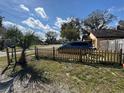 Charming front yard with a new wooden picket fence, palm tree, and grass leading up to the residence at 1224 10Th St, Holly Hill, FL 32117