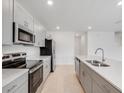 Modern kitchen with stainless steel appliances, sleek gray cabinets, and a large island with a sink at 4430 Petunia St, Lake Hamilton, FL 33851