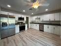 Bright kitchen with stainless steel appliances, granite countertops, white cabinets and modern lighting at 17729 Se 114Th Ct, Summerfield, FL 34491