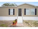 Front view of a manufactured home with steps and landscaping at 3046 Crystal Hills Dr, Lakeland, FL 33801