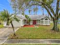 One-story house with a green exterior, red door, and attached garage at 2226 Baker Ave, Orlando, FL 32833