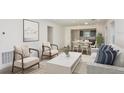 Modern living room featuring neutral furniture, stylish decor, and an open concept layout to the dining and kitchen areas at 9076 Wildlight Trl, Wildwood, FL 34785