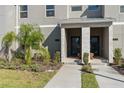 Townhome entrance with walkway, landscaping, and parking area at 8989 Cabot Cliffs Dr, Davenport, FL 33896