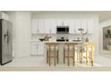 Modern kitchen with white cabinets, island, and stainless steel appliances at 1982 Sarah St, Winter Haven, FL 33884