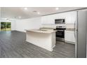 Modern kitchen with white cabinets, granite island, and stainless steel appliances at 3179 Seville St, Lake Alfred, FL 33850