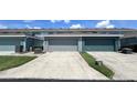 Attached garages with concrete driveway and green space at 525 Waterside Pointe Dr, Groveland, FL 34736