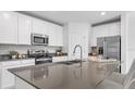 Modern kitchen with white cabinets, stainless steel appliances, and a large island at 5639 Loggia Ln, Kissimmee, FL 34758