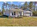House exterior showcasing a landscaped lawn and attached garage at 5830 Sw 121 St, Ocala, FL 34481