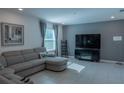 Relaxing living room with sectional sofa, large TV, and electric fireplace at 3681 Magnolia Dr, Indian Lake Estates, FL 33855