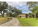 House with a long driveway and mature trees on the property at 1614 King James Ct, Lakeland, FL 33813
