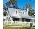 White house with gray metal roof and a white picket fence at 415 Avenue K Ne, Winter Haven, FL 33881