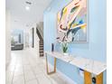 Entryway with light tile floors, a console table, stairs, and a view into the living room at 601 Drop Shot Dr, Davenport, FL 33896